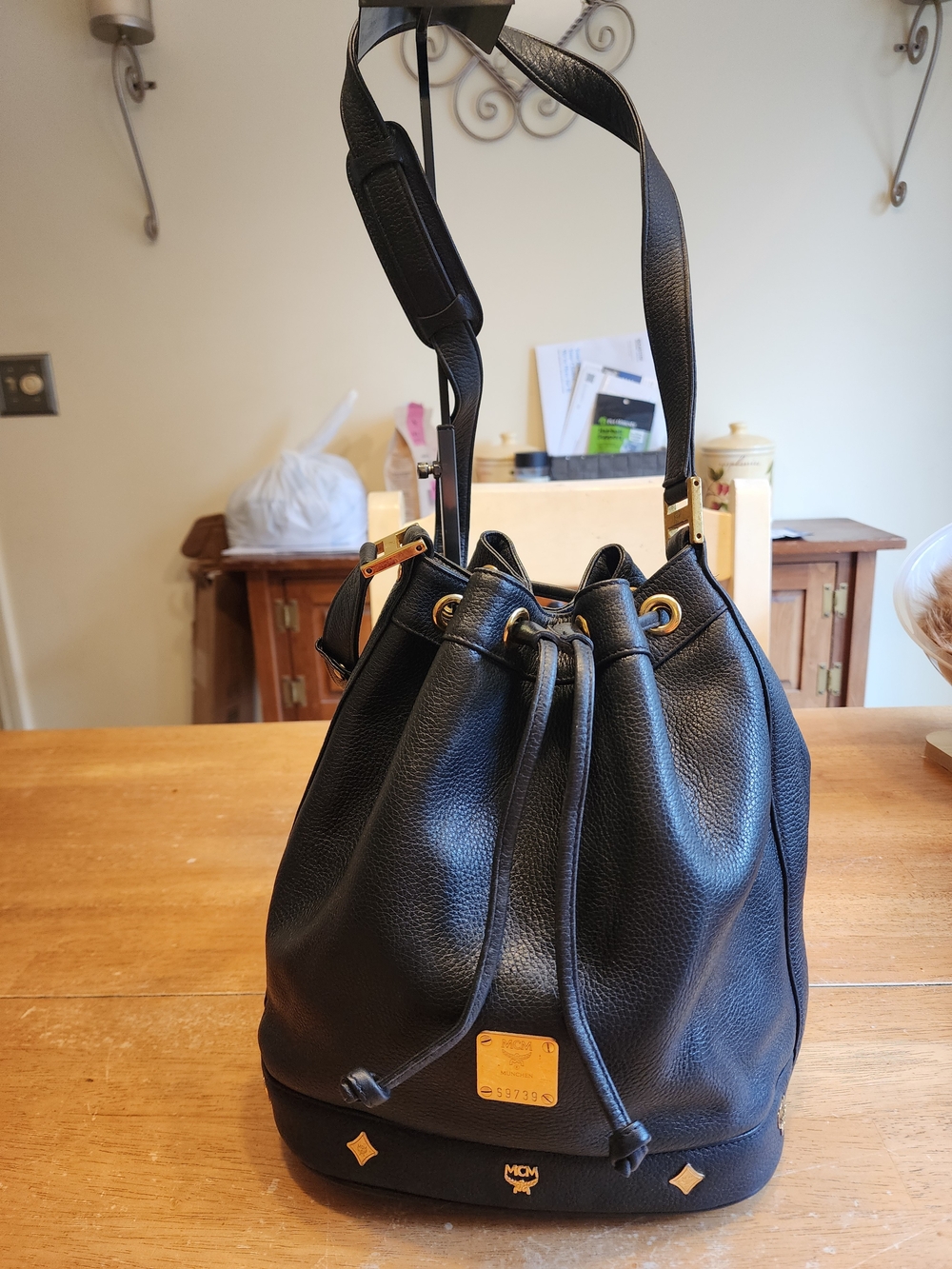 black pebbled leather MCM drawstring bucket bag featuring gold-tone hardware